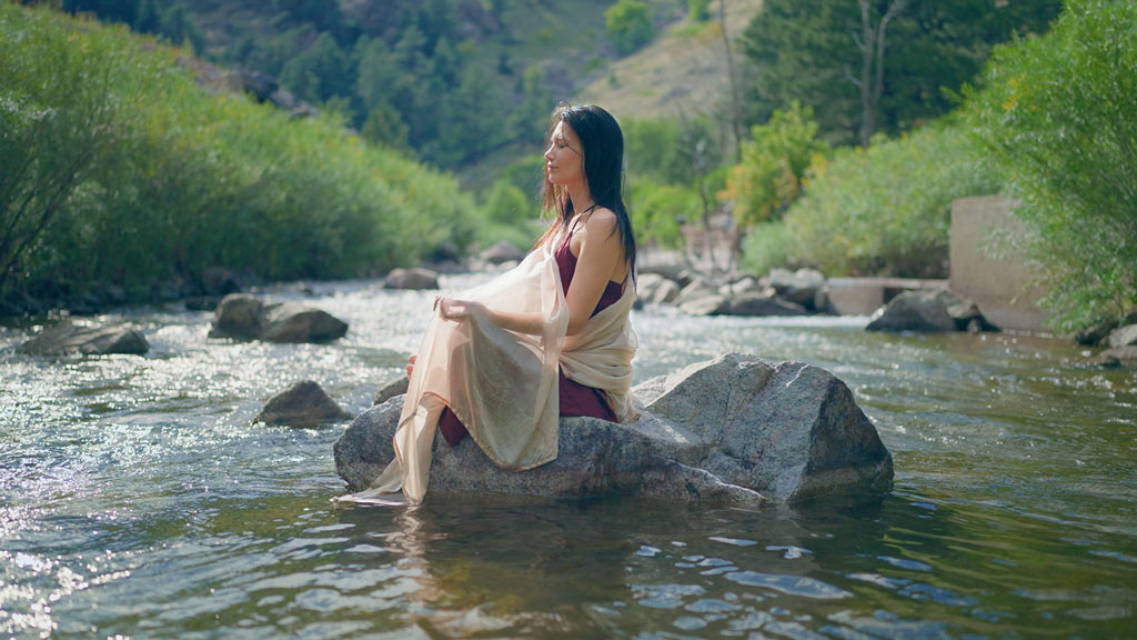 Mei-lan Maurits sitting in a river